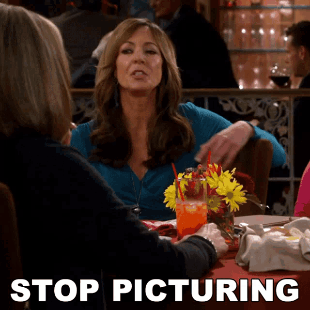 a woman sitting at a table with a glass of orange juice and the words stop picturing above her