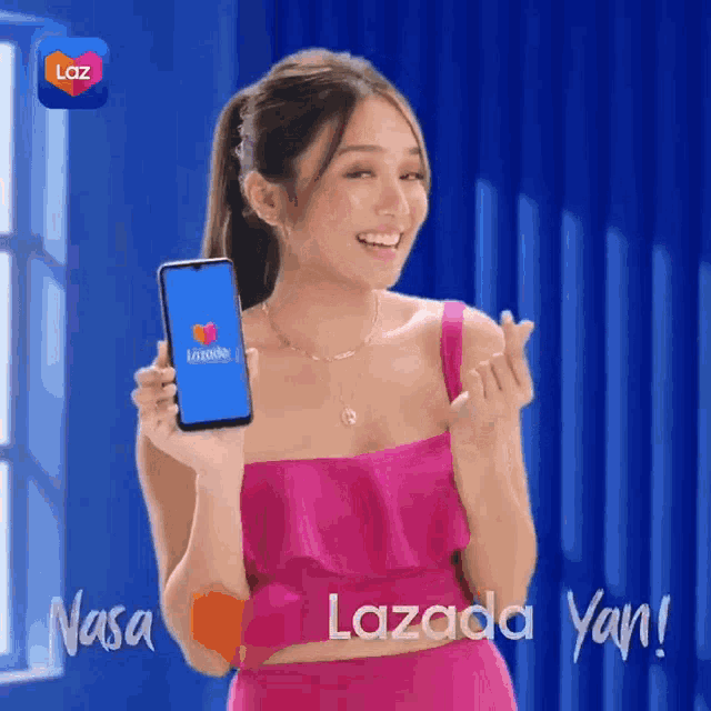 a woman in a pink top is holding a cell phone with the lazada app on it