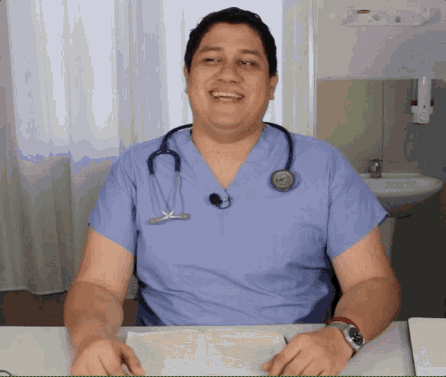 a man wearing scrubs and a stethoscope around his neck is smiling