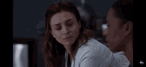 two women are sitting next to each other in a room and talking to each other .