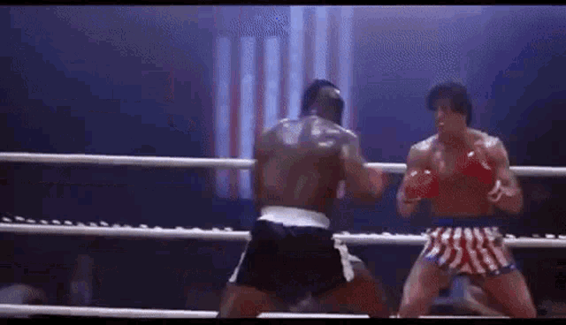 two boxers are fighting in a boxing ring .