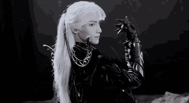 a man with white hair is wearing a black jacket