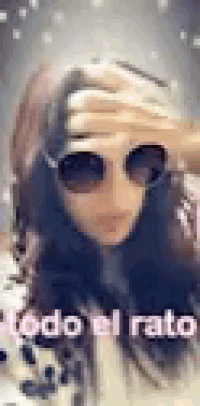 a woman wearing sunglasses is covering her face .