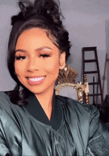 a woman is wearing a green jacket and smiling .