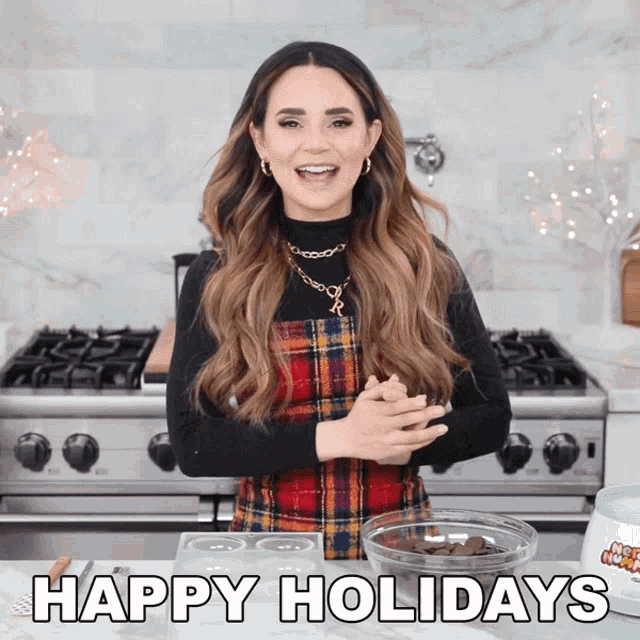 a woman standing in front of a stove with a bowl of chocolate chips and the words happy holidays above her