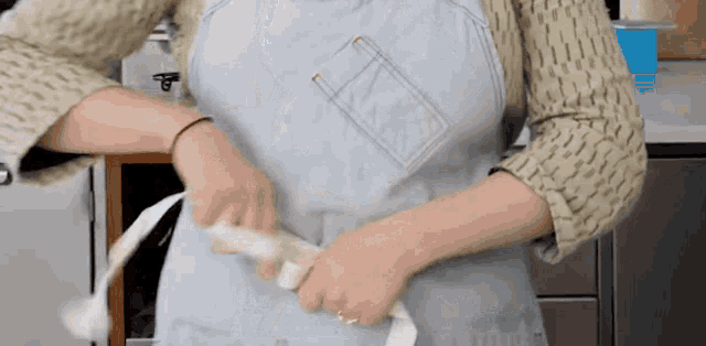a woman is wearing an apron and holding a piece of paper .