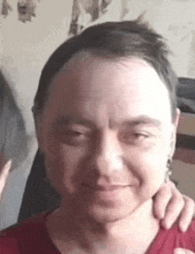 a close up of a man 's face with a woman 's hands on his neck .