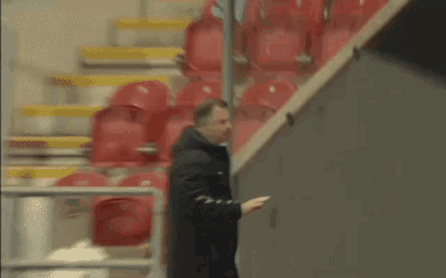 a man is walking down a set of stairs in a stadium .