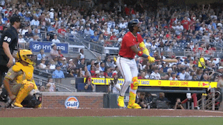a baseball player is swinging a bat at a pitch in front of a gulf sign