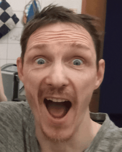 a man with a beard is making a funny face with his mouth open