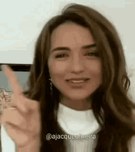 a close up of a woman giving a peace sign .