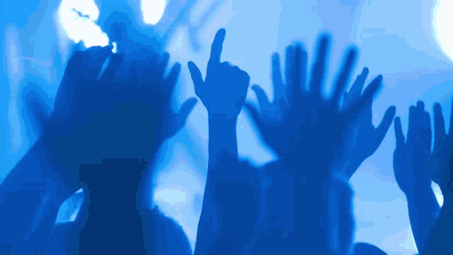 a group of people raising their hands up in the air