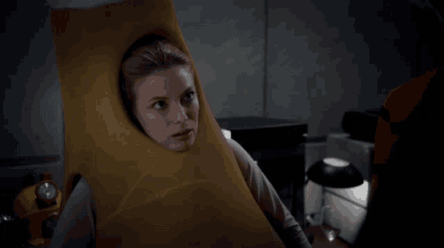 a woman is wearing a yellow costume with a hole in it