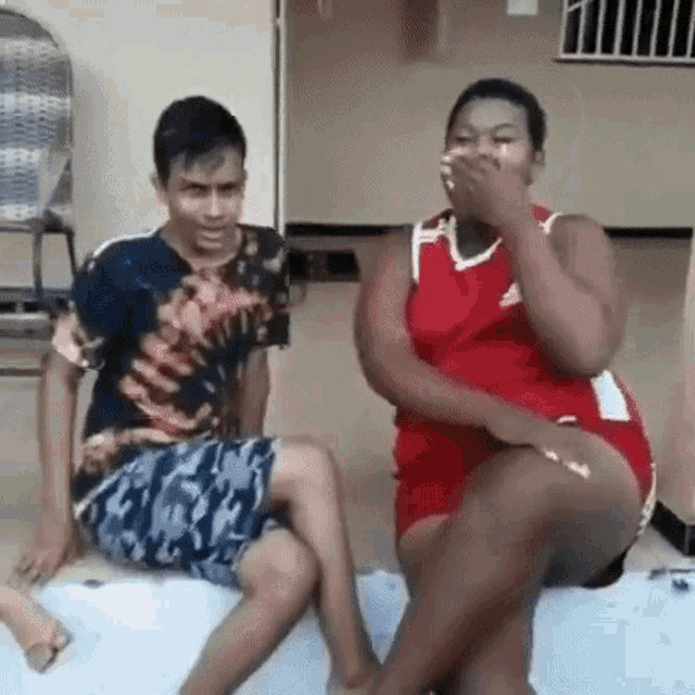 a man and a woman are sitting next to each other on a bench .