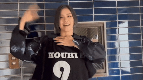 a woman wearing a black shirt that says kouki 9