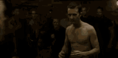 a man with blonde hair is standing next to another man without a shirt