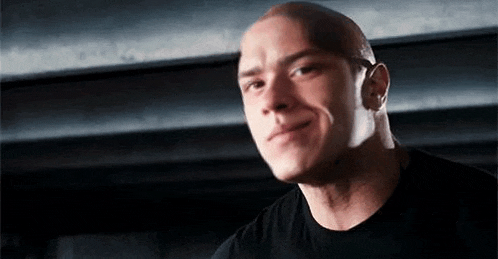 a close up of a bald man wearing a black shirt .