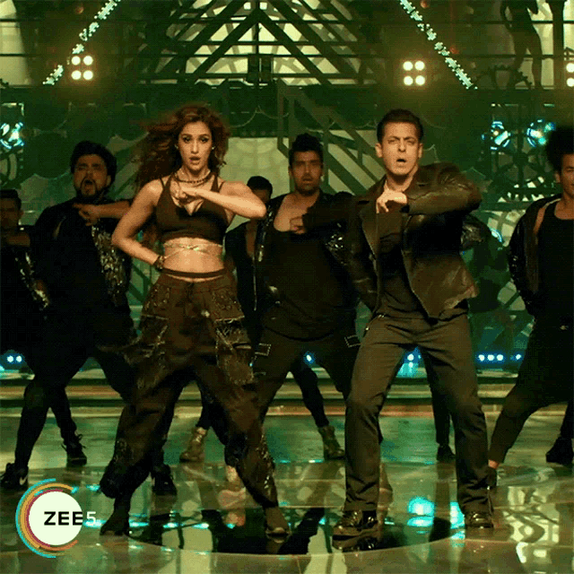a group of people are dancing in front of a sign that says zee5 on it
