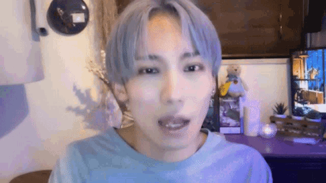 a close up of a person 's face with a blue shirt on