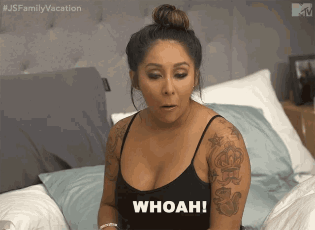a woman sitting on a bed with the word whoah on her chest
