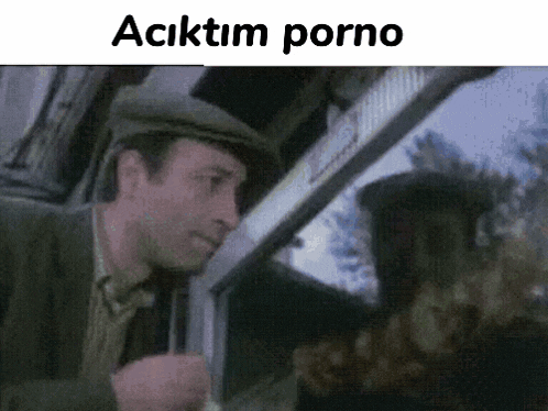 a man in a hat is looking out of a car window with the words " aciktim porno " written above him