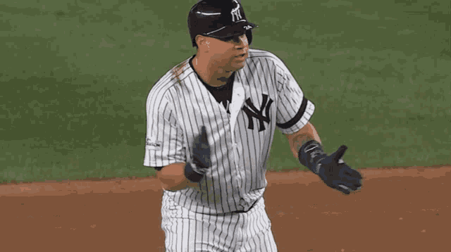 a man in a new york yankees uniform is standing on the field