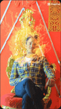 a man in a plaid shirt is sitting in front of a gold throne with fire coming out of it