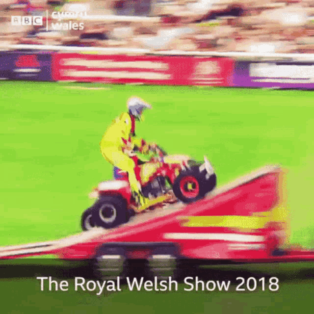 a man riding a lawn mower on a ramp at the royal welsh show