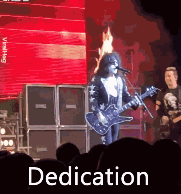 a man playing a guitar in front of a crowd with the word dedication written below him