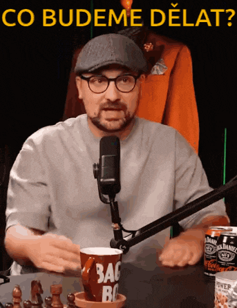 a man sitting in front of a microphone with a can of jack daniel 's on the table