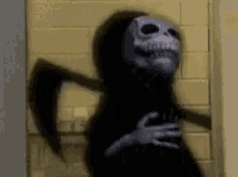 a grim reaper with a scythe is standing in a hallway .
