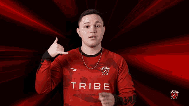 a man wearing a red shirt that says tribe on the front