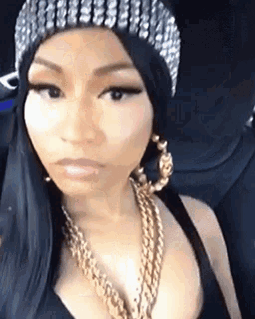 a woman wearing a beanie and a gold chain