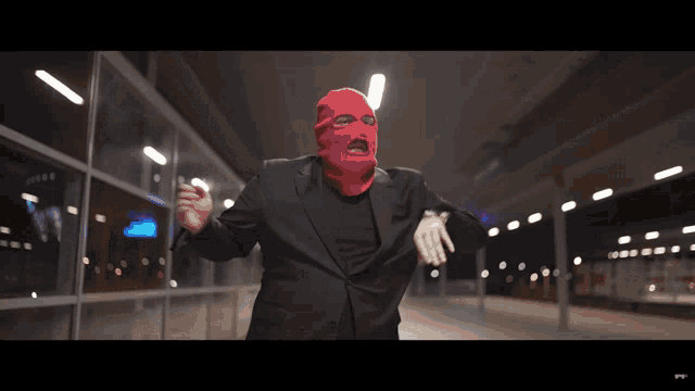 a man wearing a red mask and a black jacket