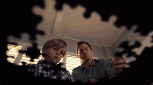 a man and a boy are playing with a puzzle together