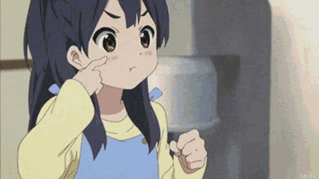 a girl with a yellow shirt and a blue apron is making a funny face