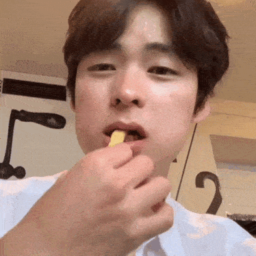 a close up of a person eating a piece of food with the number 2 on the wall behind them