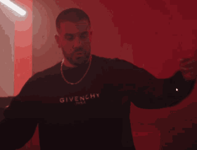 a man wearing a black sweater that says givenchy paris