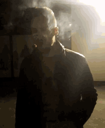 a man in a leather jacket smoking a cigar