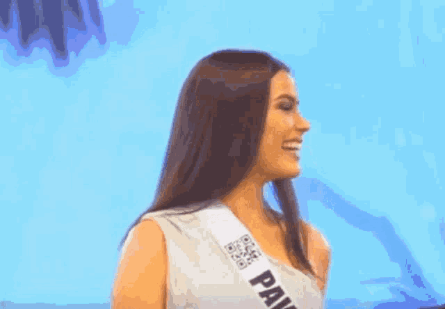 a woman wearing a sash that says ' panama ' on it is smiling .