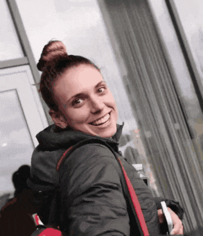 a woman with a bun on her head is smiling in front of a glass door