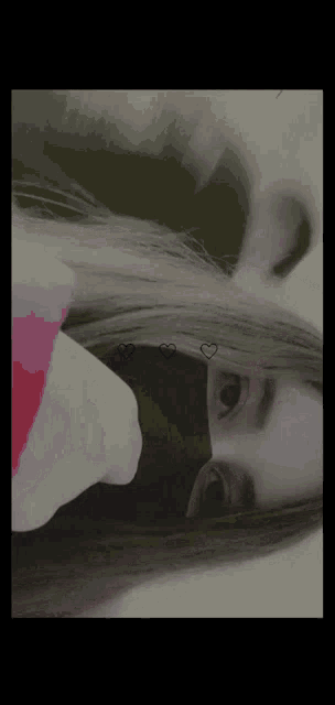 a girl with long hair is wearing a black mask with hearts on it