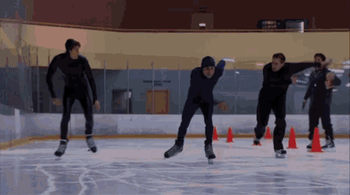 a group of men are ice skating on a rink with a sign in the background that says ' ice rink '