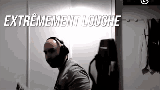 a man wearing headphones is standing in front of a wall that says extremement louche