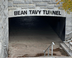 stairs leading up to bean tavy tunnel with a sign above it