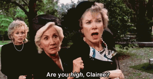 three older women are standing next to each other in a park .