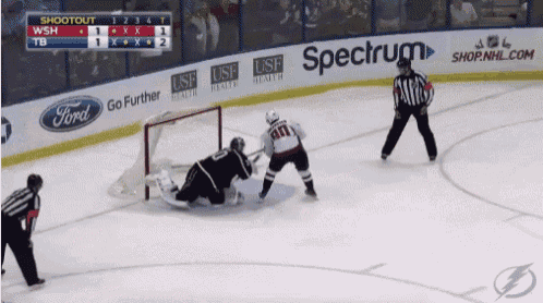 a hockey game is being played in front of a spectrum banner