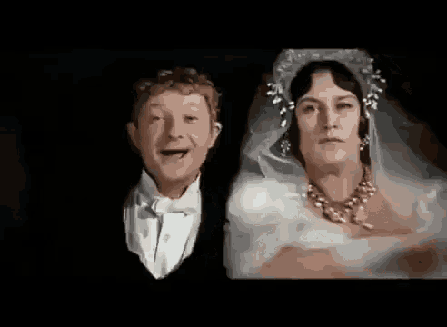a man in a tuxedo is standing next to a woman in a bride 's dress .