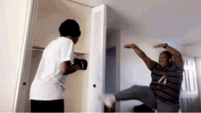 a man wearing boxing gloves kicks another man in the leg