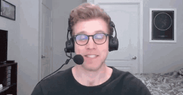 a man wearing glasses and a headset is smiling